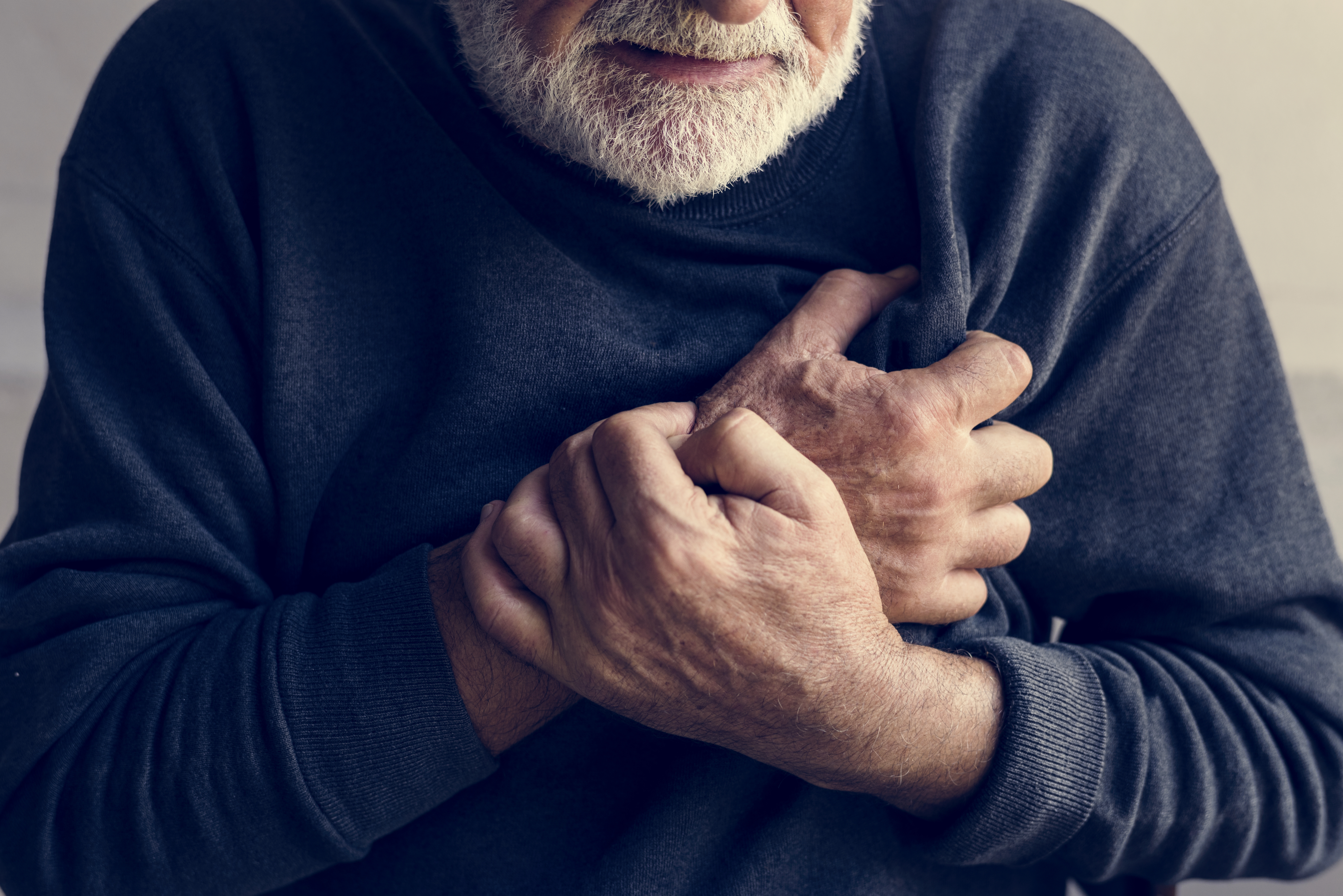 Close up of elderly man having a heart attack